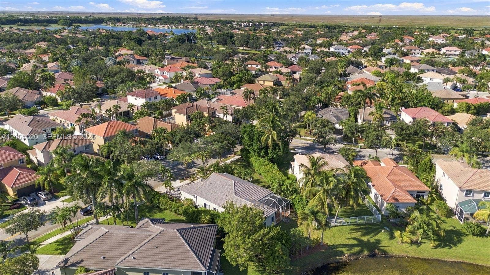 649 Willow Bend Road, Weston, Weston, FL 33327 Aerial perspective featuring mature tropical landscaping, tile roof construction, and a water frontage location