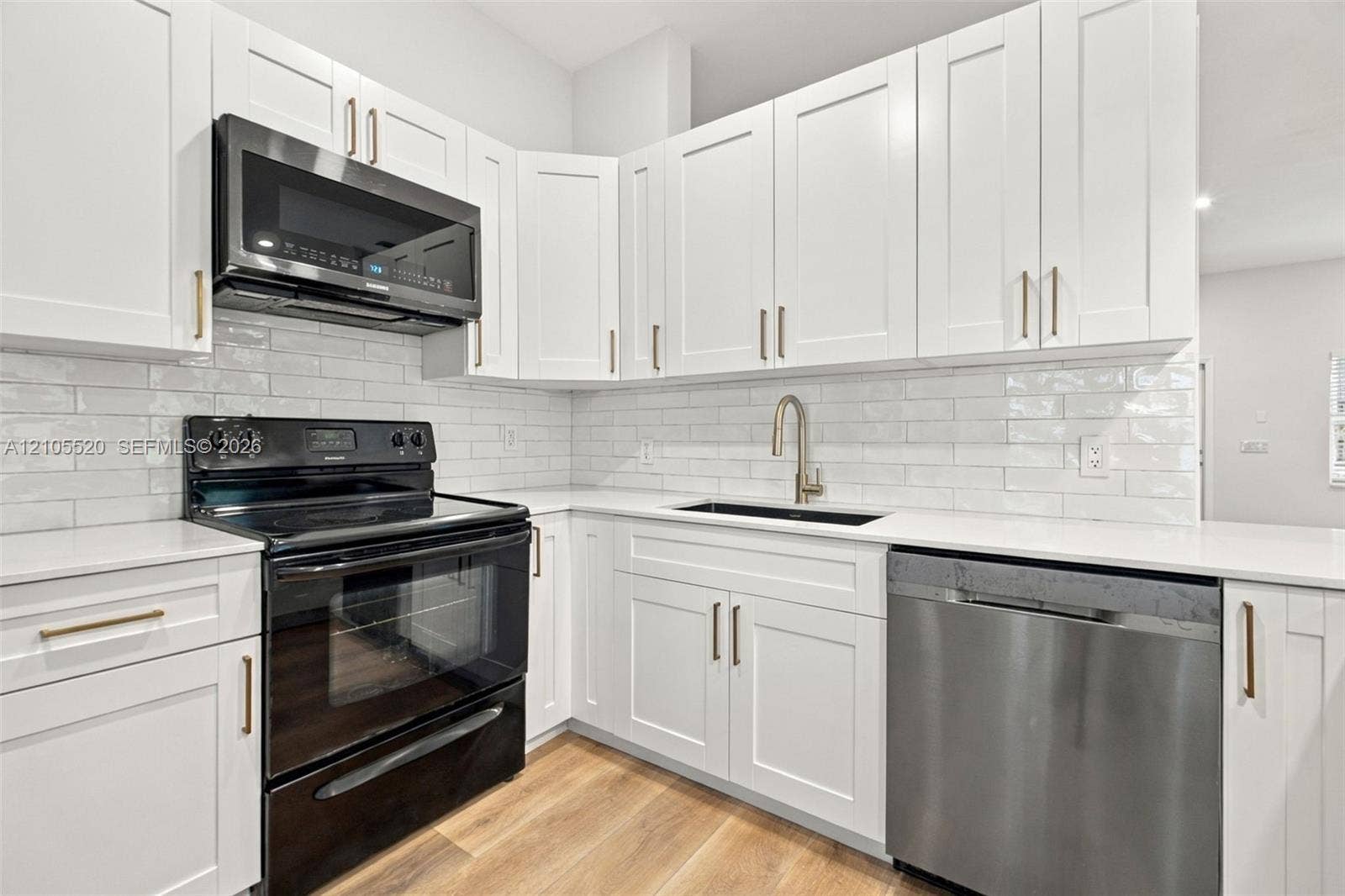 649 Willow Bend Road, Weston, Weston, FL 33327 Kitchen featuring shaker-style cabinetry, quartz countertops, subway tile backsplash, stainless steel appliances, and wood-finish flooring