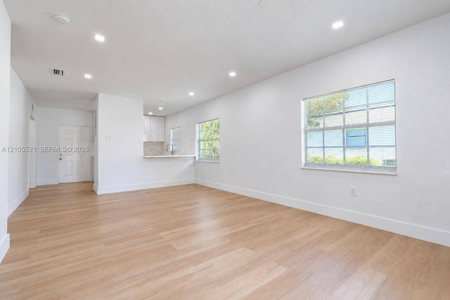 Spacious interior with light wood-finish flooring and recessed lighting
