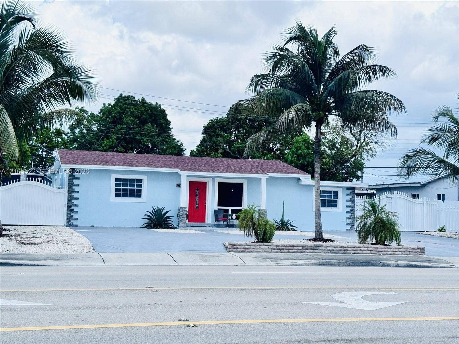 Light blue exterior with white trim windows and a red entry door