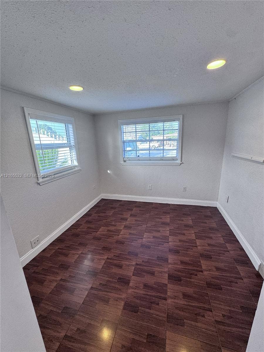 Wood-finish flooring, recessed lighting, and two windows with blinds