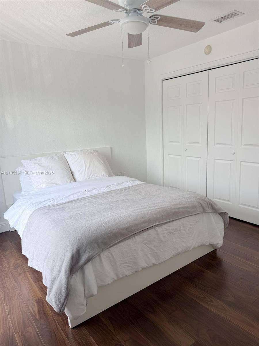 Wood-finish flooring, ceiling fan with light fixture, and bi-fold closet doors