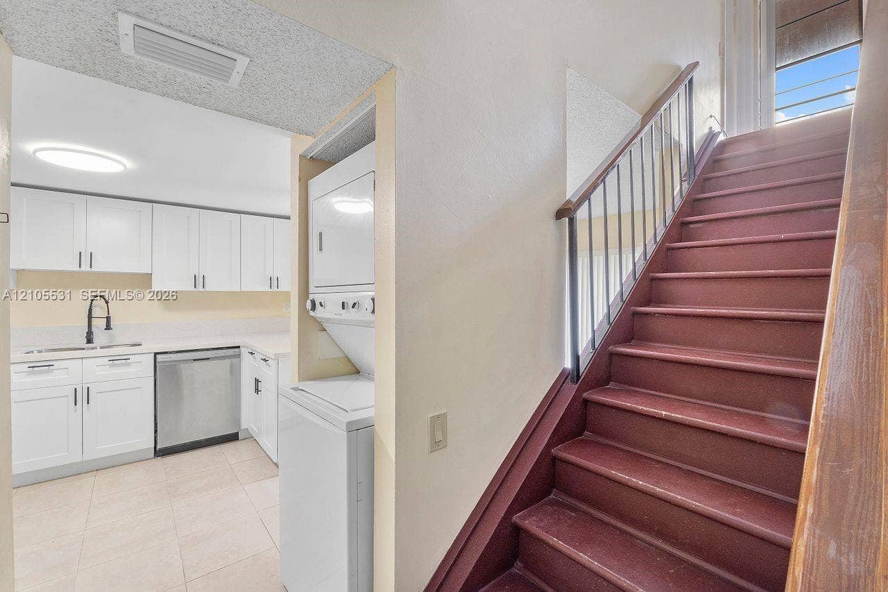 Kitchenette with white cabinetry, light countertops, and stainless steel appliances