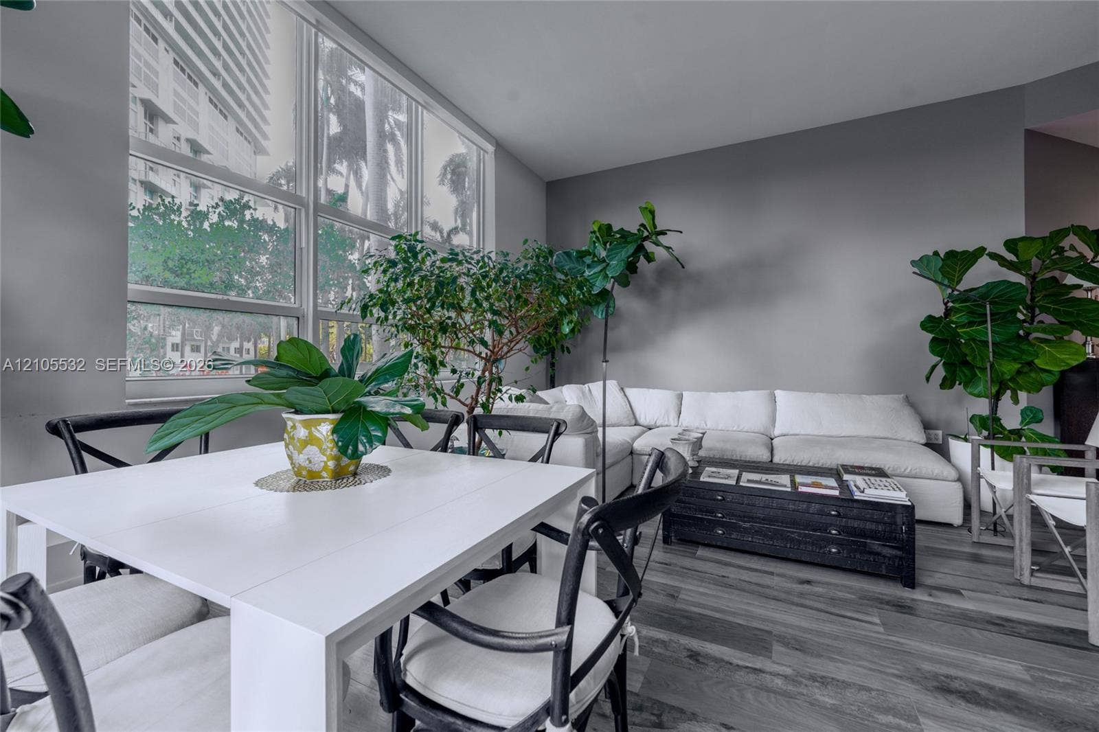 Floor-to-ceiling windows, wood-finish flooring, and neutral wall tones