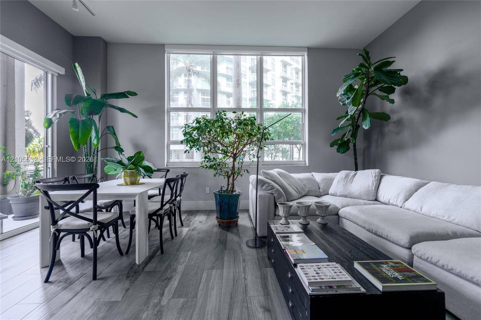 Living area featuring wood-finish flooring, floor-to-ceiling windows, and access to an exterior terrace