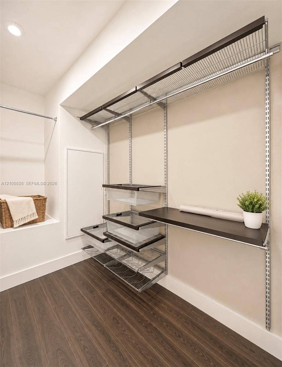 Recessed lighting, wood-finish flooring, built-in shelving system with hanging rods, built-in desk, and wire pull-out drawers