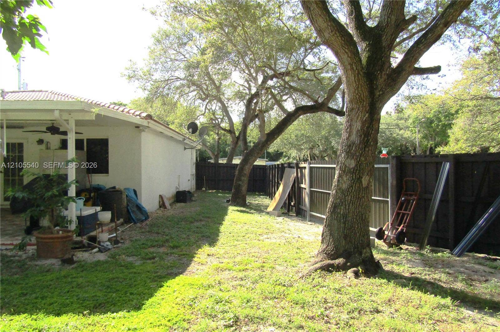 21935 SW 102nd Avenue, Cutler Bay, FL 33190 Expansive lawn area featuring mature trees and a privacy fence