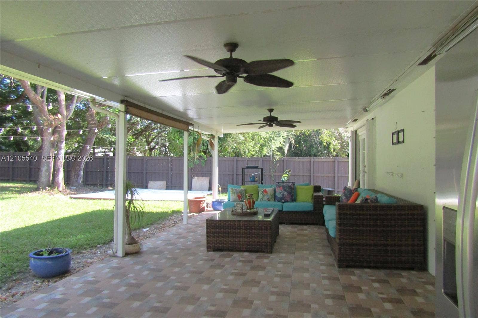 21935 SW 102nd Avenue, Cutler Bay, FL 33190 Expansive covered patio featuring a tiled floor, dual ceiling fans, and a solid perimeter fence
