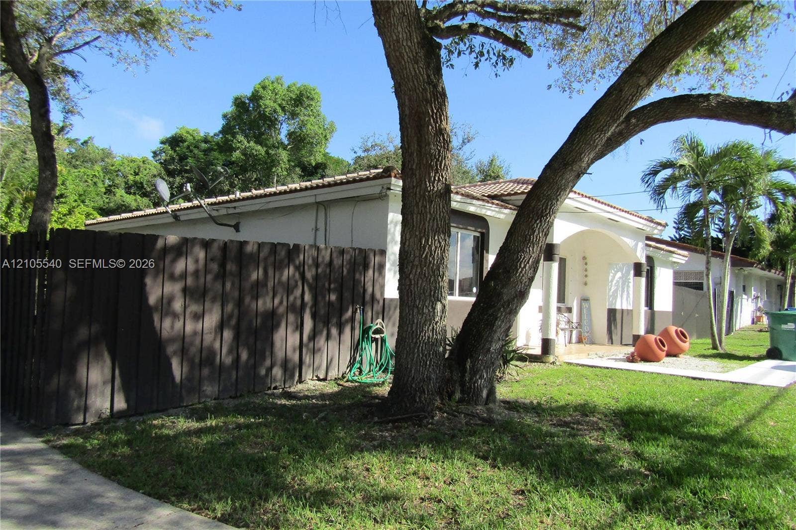 21935 SW 102nd Avenue, Cutler Bay, FL 33190 Picket fencing with a dark wood finish, mature trees, and a manicured lawn