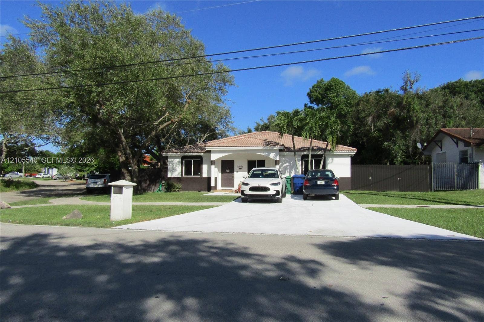 21935 SW 102nd Avenue, Cutler Bay, FL 33190 Single-story residence with a light-colored stucco exterior, dark trim, and a tile roof