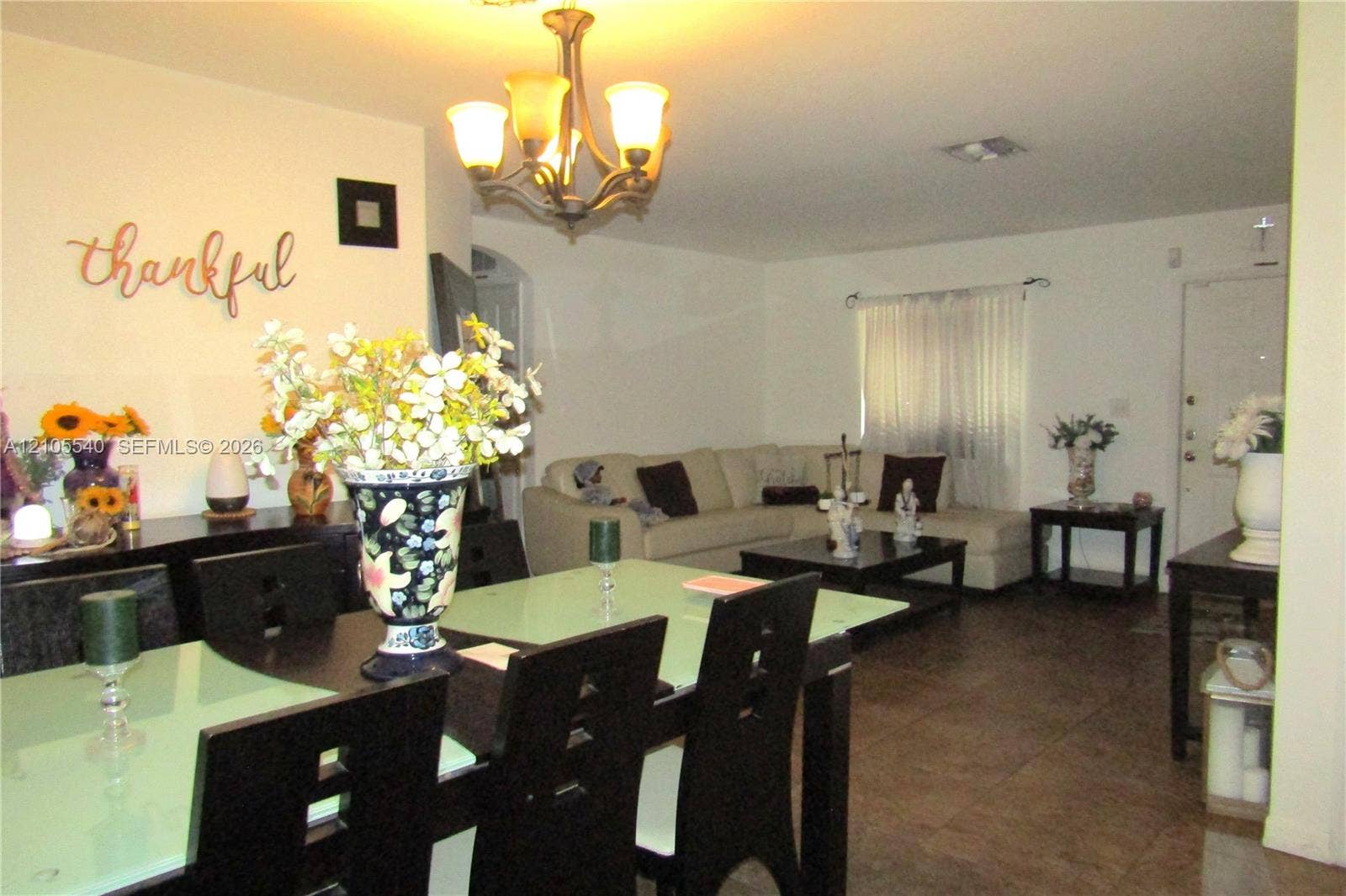 21935 SW 102nd Avenue, Cutler Bay, FL 33190 Open concept living and dining areas featuring dark wood-finish flooring, a decorative archway, and a chandelier light fixture