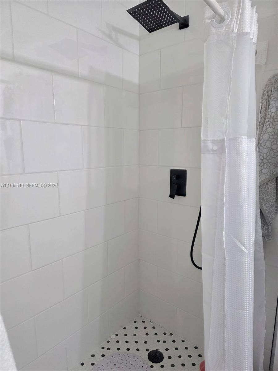 21935 SW 102nd Avenue, Cutler Bay, FL 33190 Shower with white subway tile, a matte black shower head, and a black and white mosaic tile floor