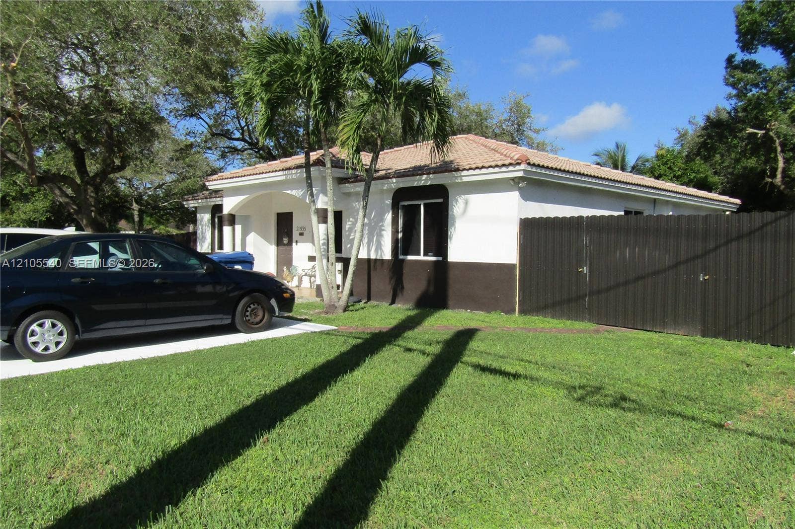 21935 SW 102nd Avenue, Cutler Bay, FL 33190 White exterior with a brown lower facade, featuring a red tile roof and a concrete driveway