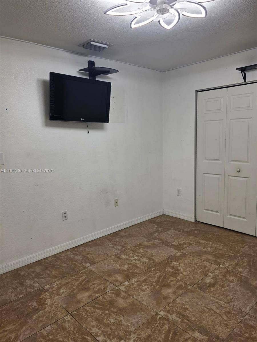 21935 SW 102nd Avenue, Cutler Bay, FL 33190 Tile flooring with a neutral finish, white walls, and a ceiling-mounted fan with integrated lighting