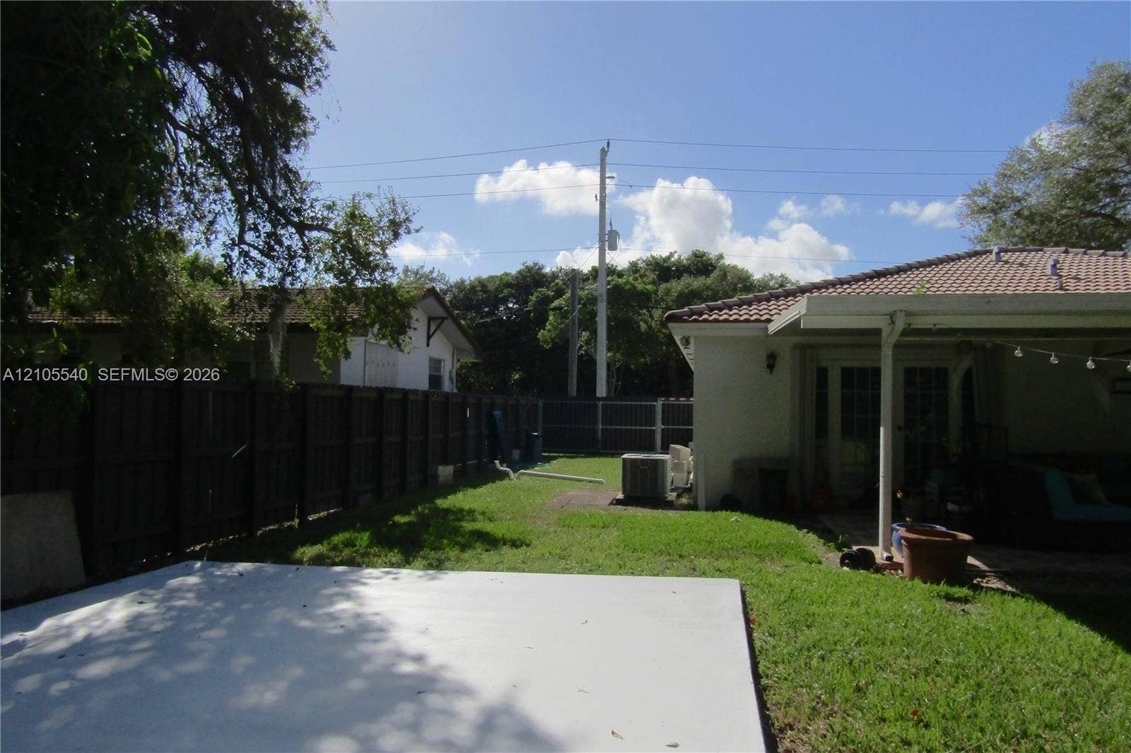 21935 SW 102nd Avenue, Cutler Bay, FL 33190 Expansive outdoor space featuring a concrete patio, grassy lawn, and wood-panel fencing