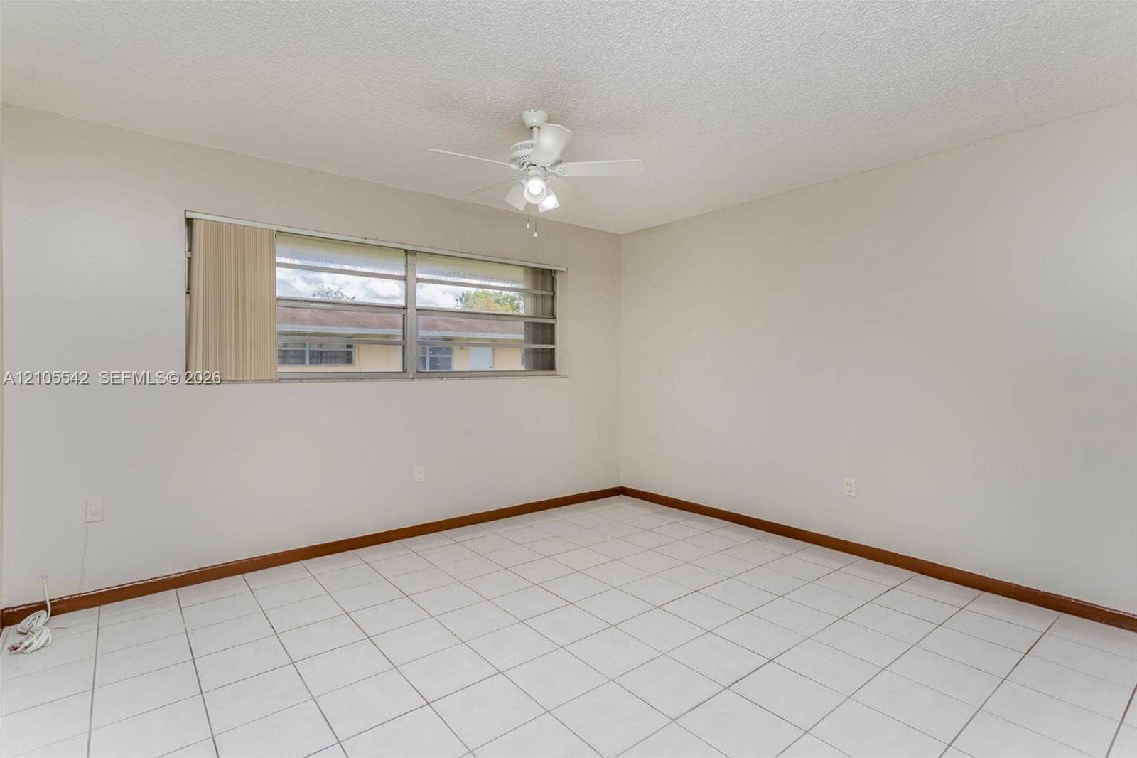White tile flooring, a window with horizontal blinds, and a ceiling fan with light fixture
