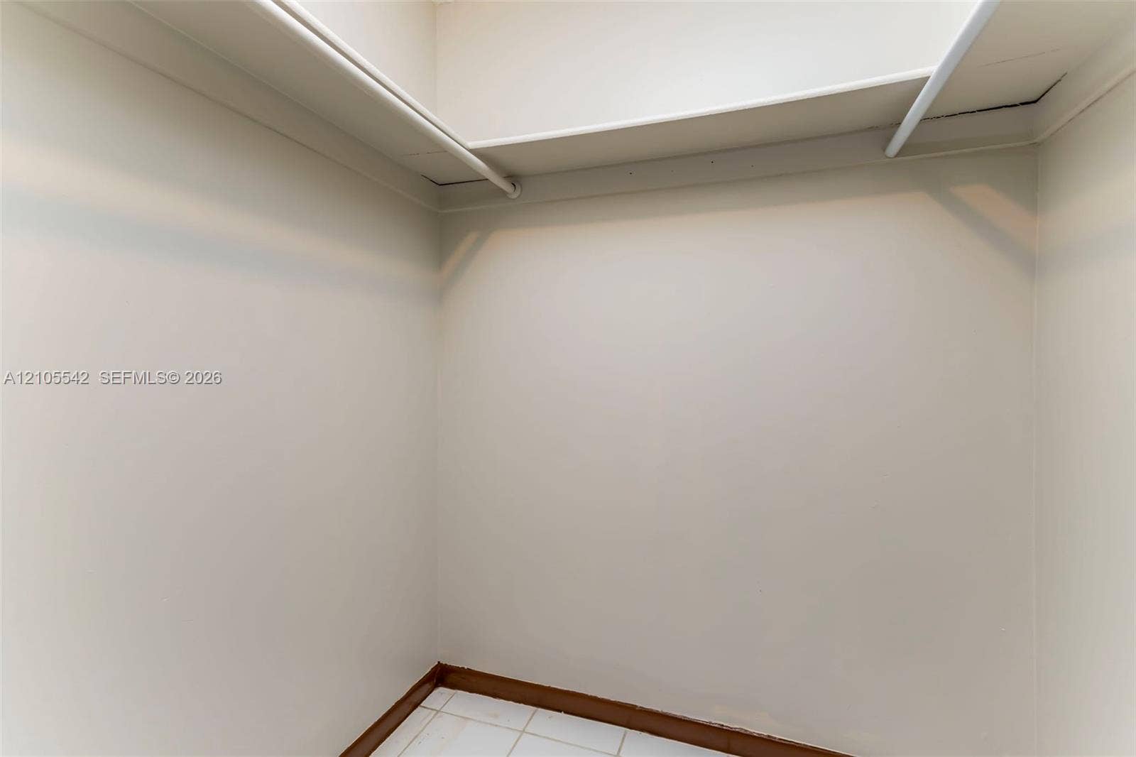 White walls with a single shelf and hanging rod