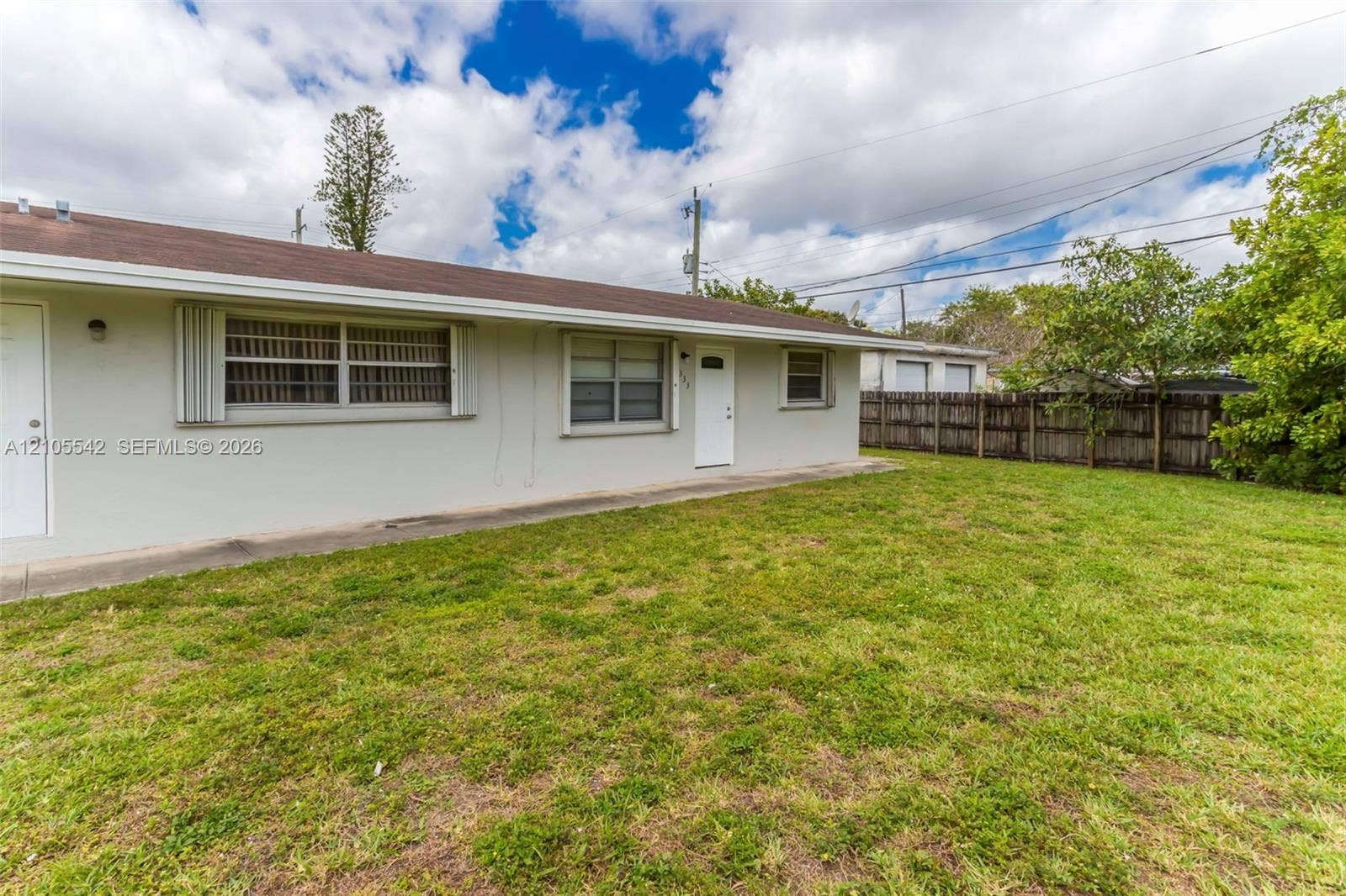 Expansive yard with mature landscaping and a wood fence
