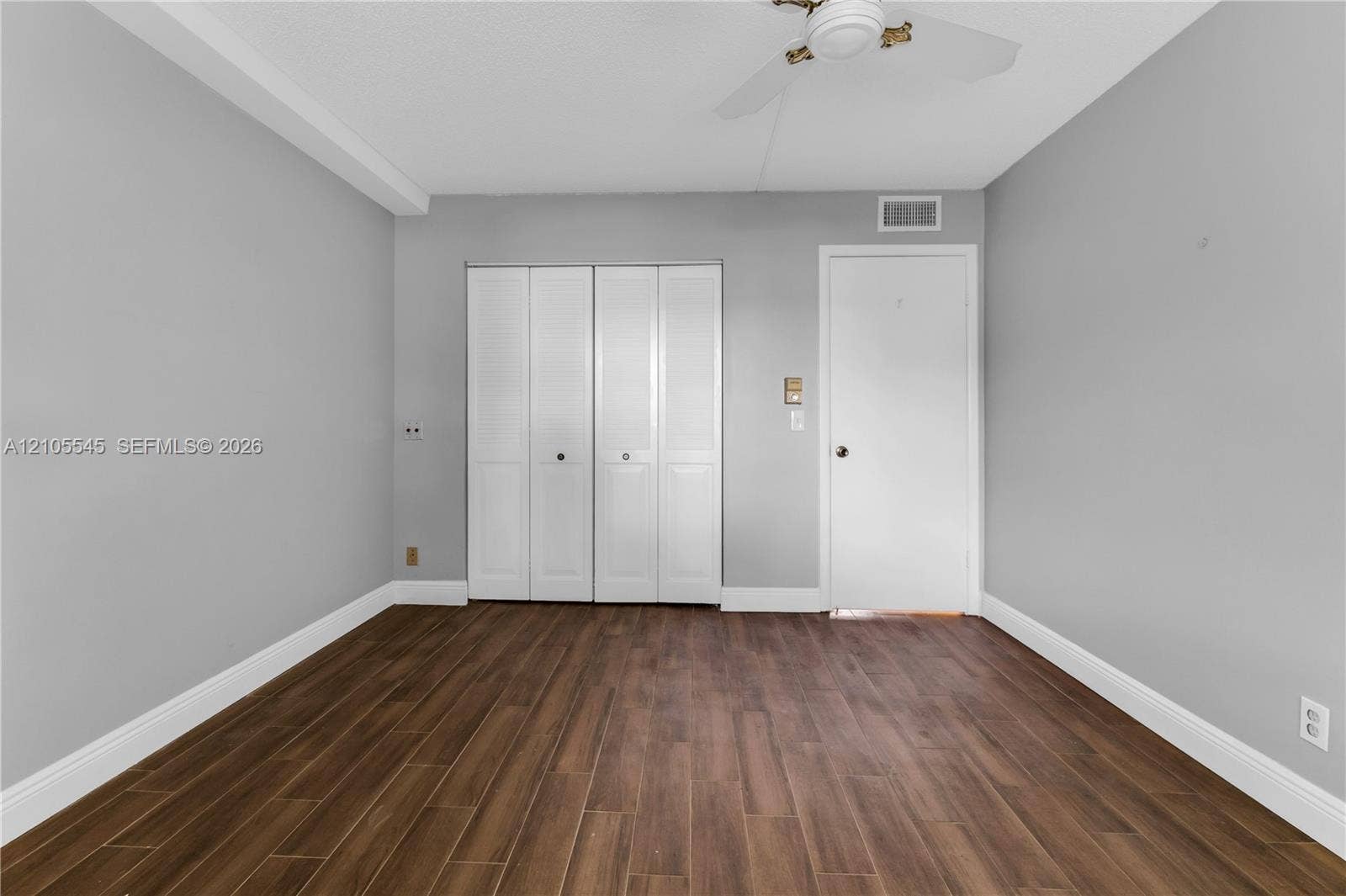222 Tilford A, #222, Deerfield Beach, FL 33442 Wood-finish ceramic flooring, white bi-fold closet doors, ceiling fan, and light gray wall paint
