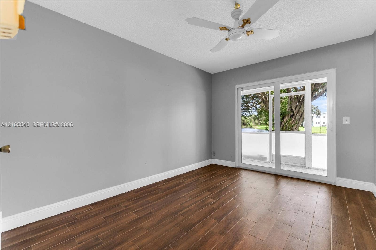 222 Tilford A, #222, Deerfield Beach, FL 33442 Wood-finish ceramic flooring with light gray walls, white baseboards, and a ceiling fan