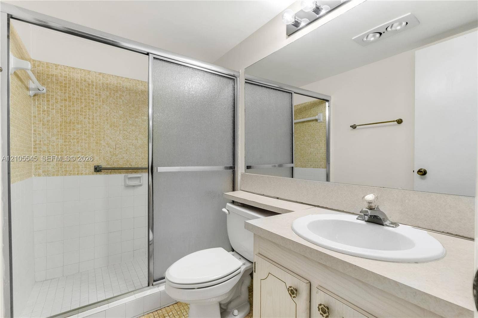 222 Tilford A, #222, Deerfield Beach, FL 33442 Shower enclosure with sliding frosted glass doors, a vanity with an integrated sink and base cabinetry, and a full-width mirror