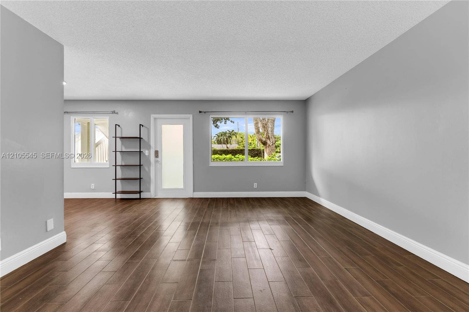 222 Tilford A, #222, Deerfield Beach, FL 33442 Wood-finish ceramic flooring, light grey painted walls, white baseboards, and multiple windows providing natural light