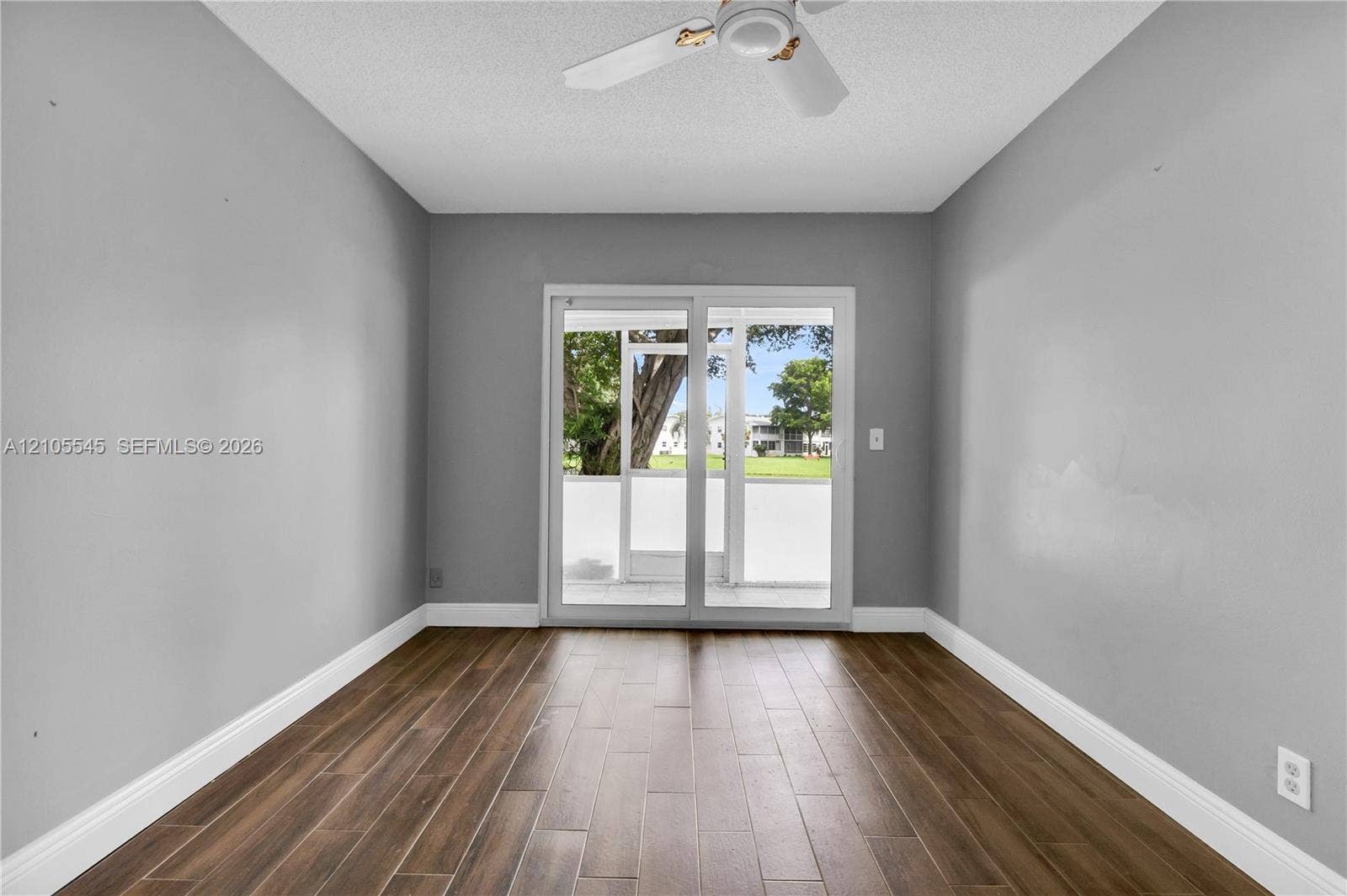 222 Tilford A, #222, Deerfield Beach, FL 33442 Wood-finish ceramic flooring, neutral gray walls, bright white trim, and a ceiling fan