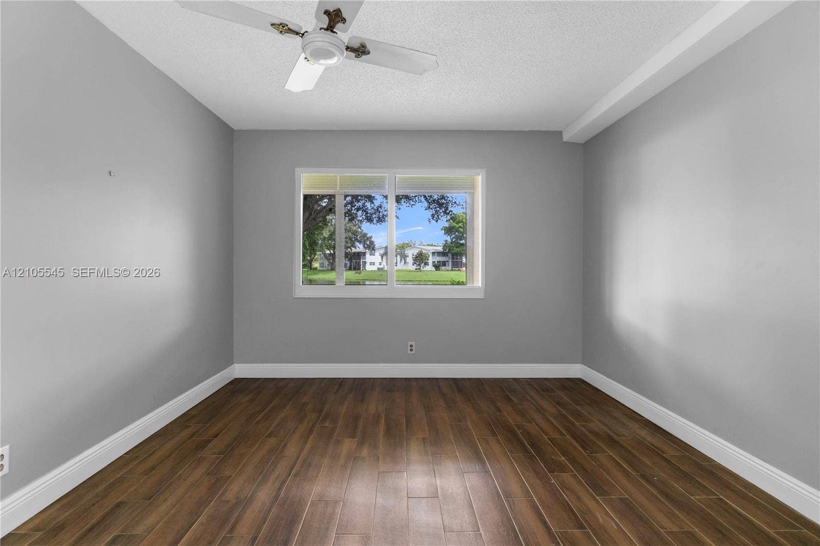 222 Tilford A, #222, Deerfield Beach, FL 33442 Wood-finish ceramic flooring, white trim, a ceiling fan, and a prominent window
