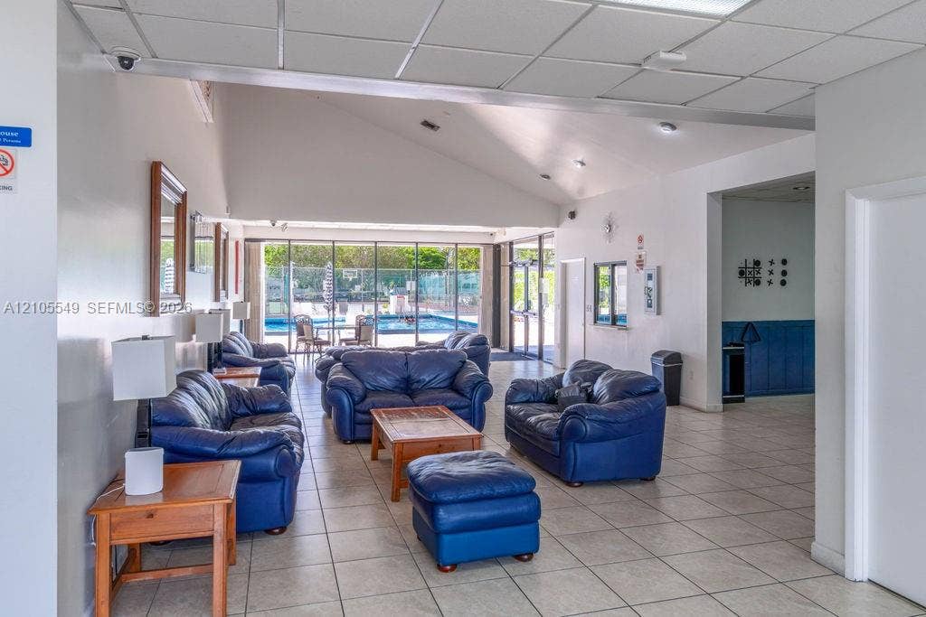 Spacious common area featuring tiled flooring and a high vaulted ceiling