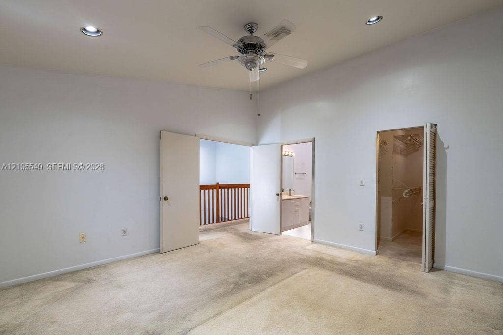 Vaulted ceiling featuring a ceiling fan, recessed lighting, and carpeted flooring