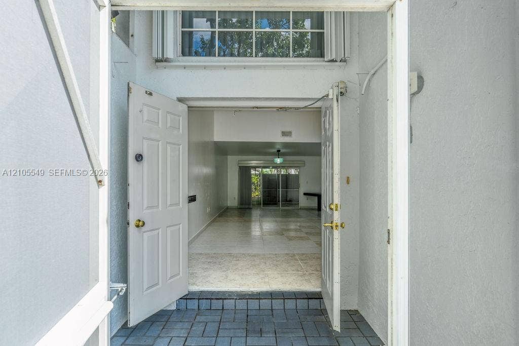 Entryway featuring a panel door, tiled flooring, and an overhead window
