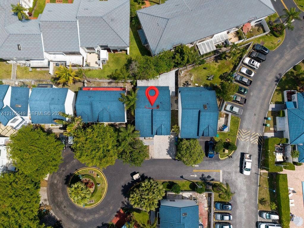 Aerial perspective of the property, featuring a blue-tiled roof and surrounding green spaces
