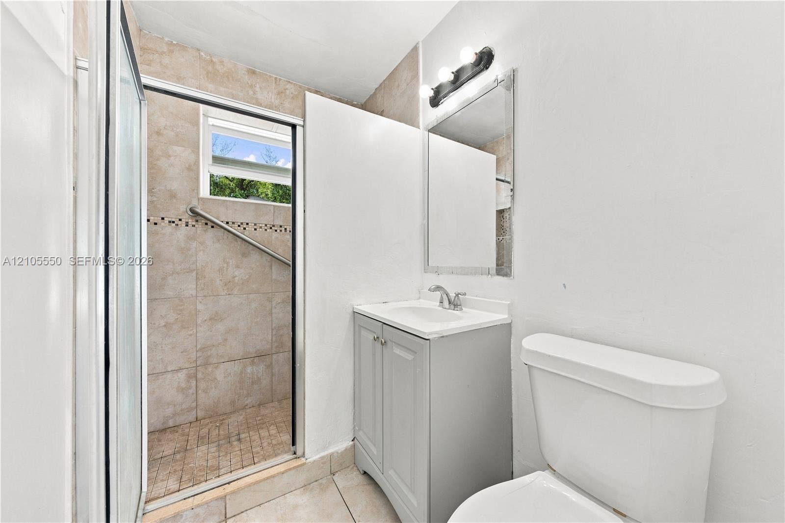 Tiled shower enclosure with glass sliding door and grab bar