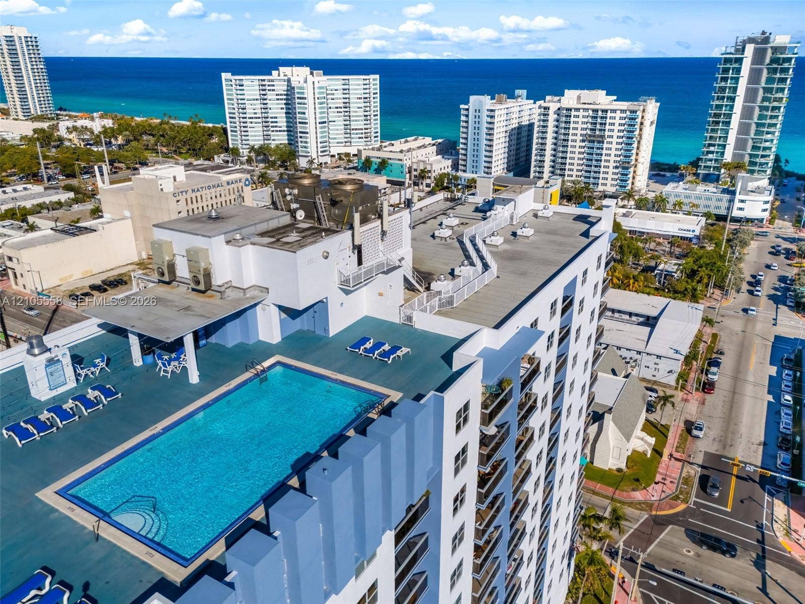Rooftop pool deck featuring a rectangular swimming pool with integrated steps, shaded seating area, and surrounding lounge space
