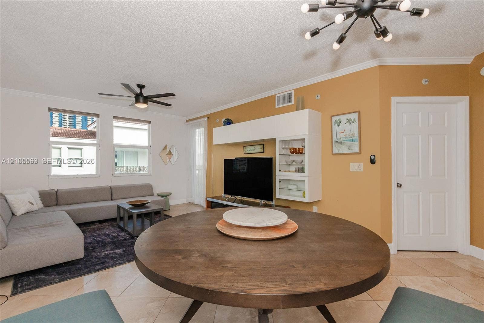 17145 N Bay Road, #4613, Sunny Isles Beach, Sunny Isles Beach, FL 33160 Open-concept living space featuring tile flooring, a dark wood-finish dining table, and a modern ceiling fan