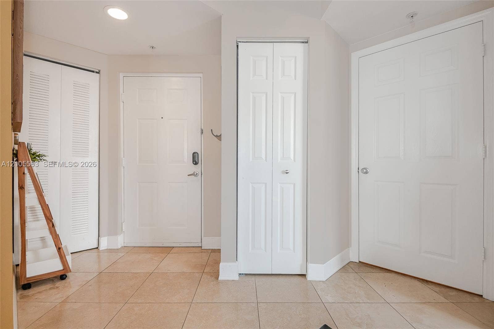 17145 N Bay Road, #4613, Sunny Isles Beach, Sunny Isles Beach, FL 33160 Tiled flooring with a white paneled door, louvered bi-fold door, and paneled bi-fold door