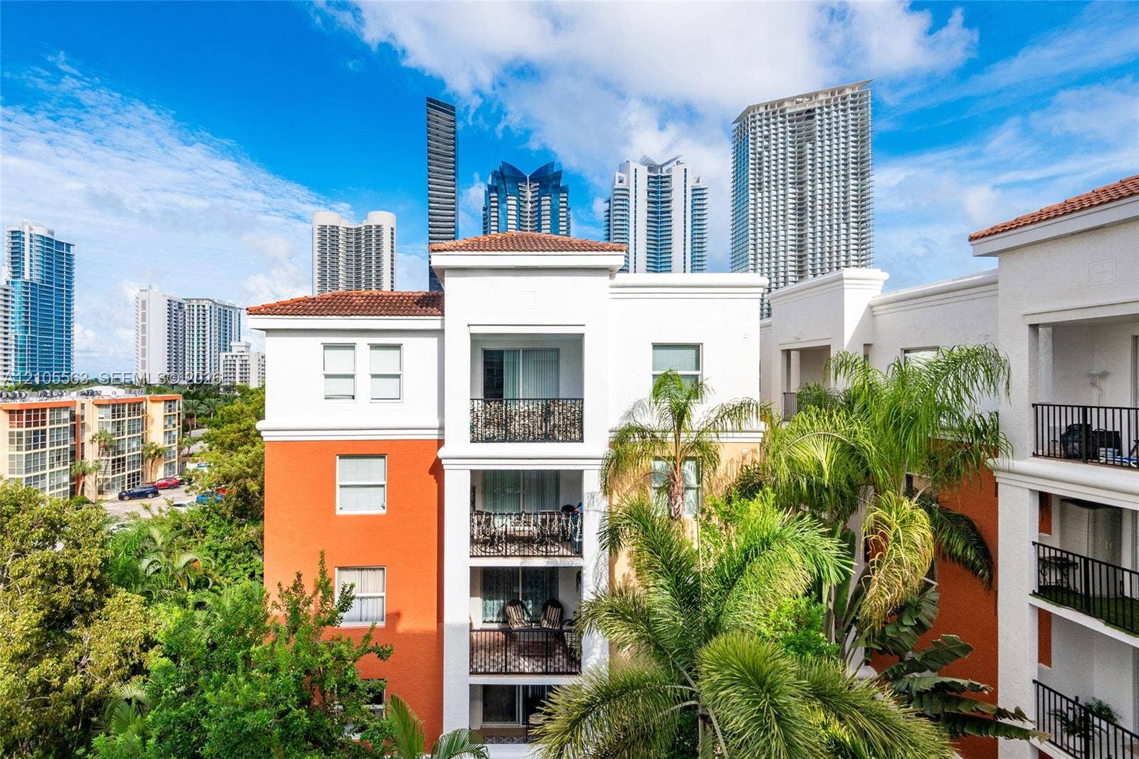 17145 N Bay Road, #4613, Sunny Isles Beach, Sunny Isles Beach, FL 33160 Multi-story building with white and orange exterior, tile roof accents, and multiple balconies featuring black wrought iron railings