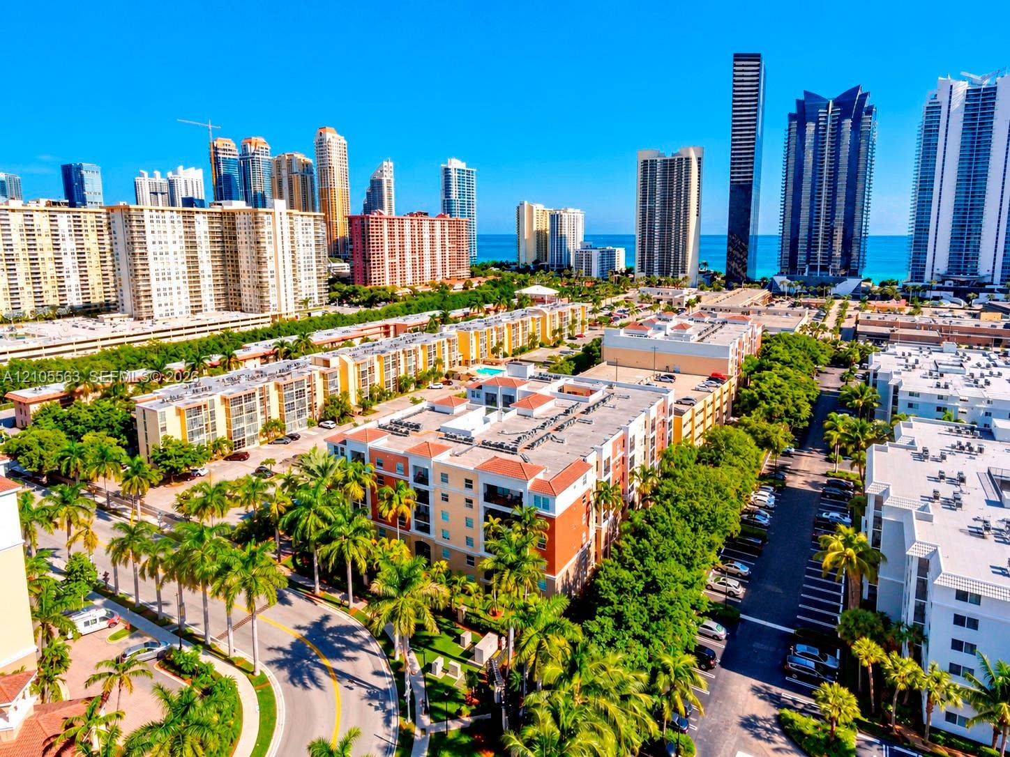 17145 N Bay Road, #4613, Sunny Isles Beach, Sunny Isles Beach, FL 33160 Expansive urban landscape featuring multiple multi-story residential buildings, abundant mature palm trees, and visible clear blue water