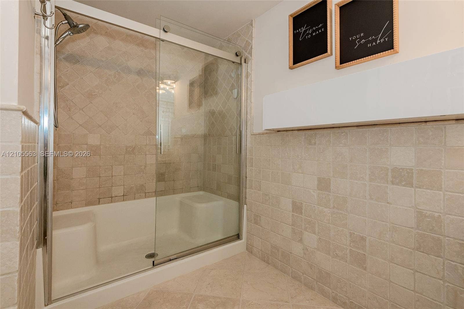 17145 N Bay Road, #4613, Sunny Isles Beach, Sunny Isles Beach, FL 33160 Shower enclosure with sliding glass door, integrated seating, and full-height tile surround