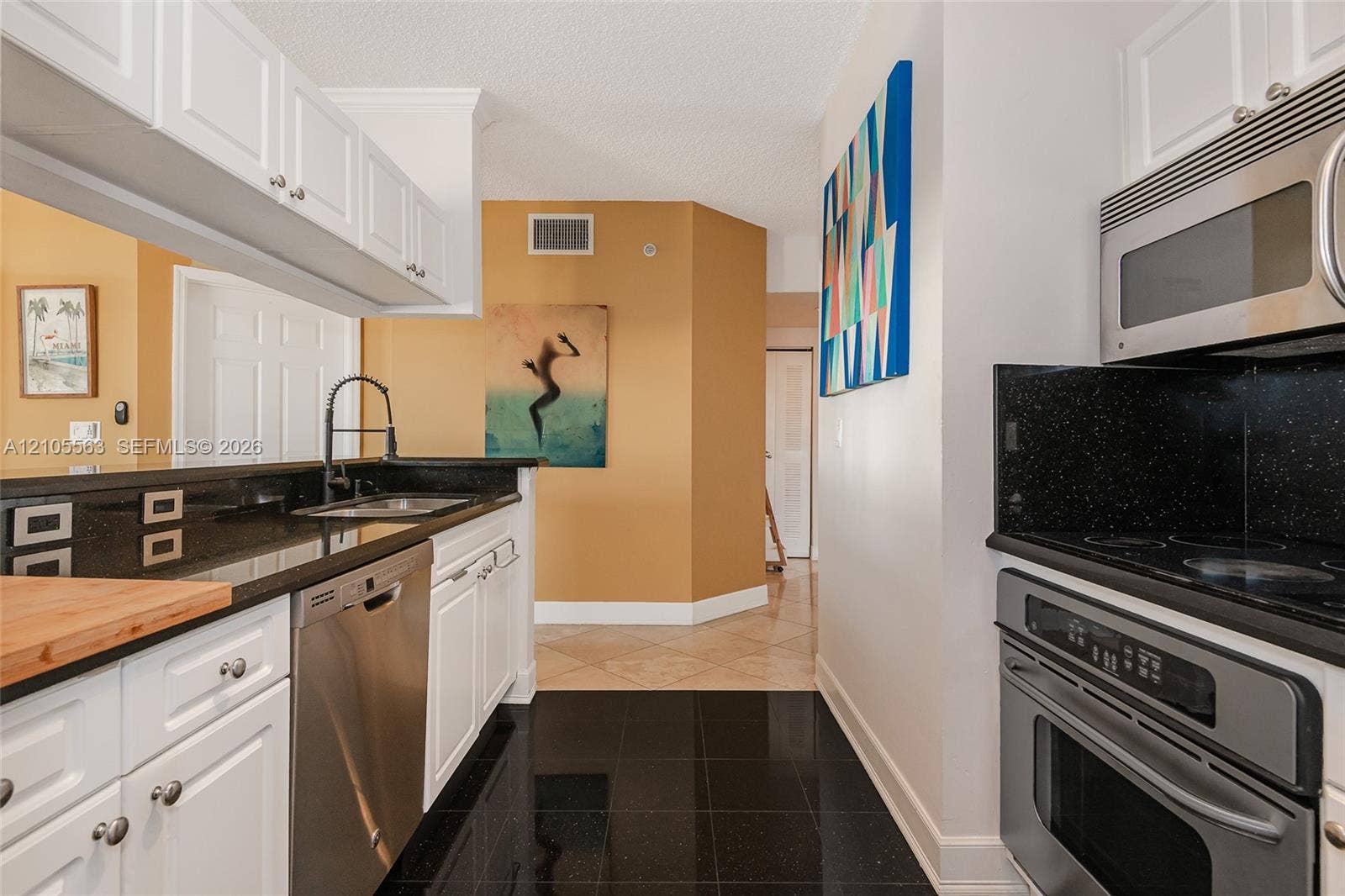 17145 N Bay Road, #4613, Sunny Isles Beach, Sunny Isles Beach, FL 33160 White shaker-style cabinetry with stainless steel appliances, black countertops, and a black pull-down faucet