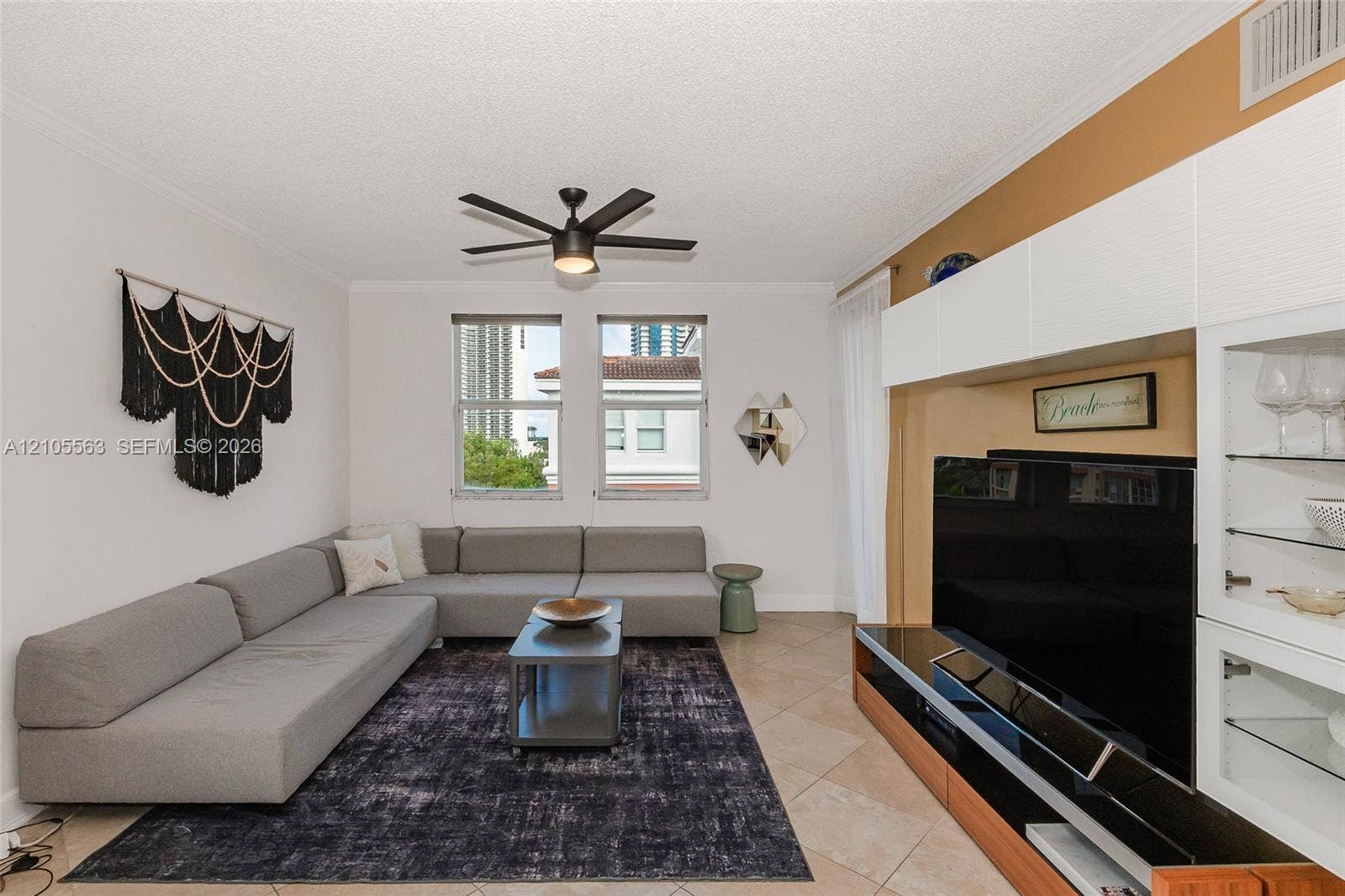 17145 N Bay Road, #4613, Sunny Isles Beach, Sunny Isles Beach, FL 33160 Recessed lighting, ceiling fan with integrated light, tiled flooring, built-in media storage with glass shelving, and window with blinds