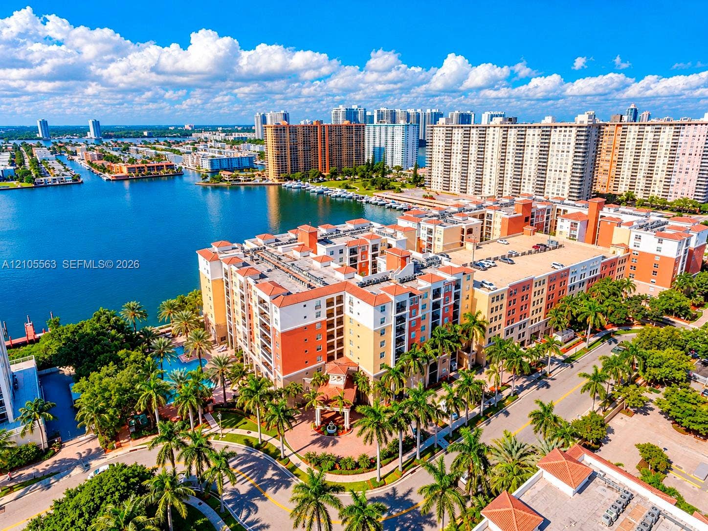 17145 N Bay Road, #4613, Sunny Isles Beach, Sunny Isles Beach, FL 33160 Multi-story building with a terracotta-style roof, multiple balconies, and a vibrant exterior color palette