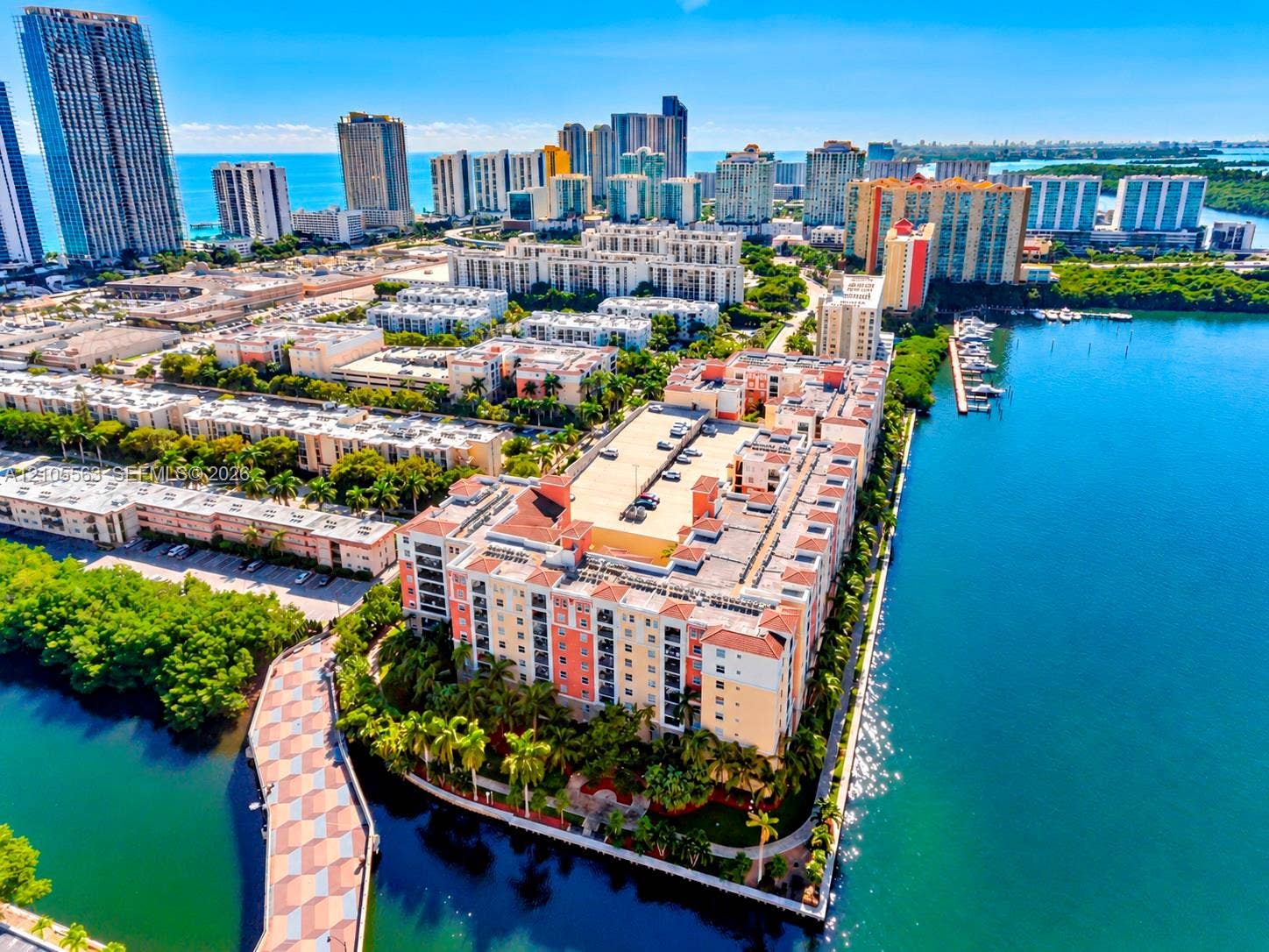 17145 N Bay Road, #4613, Sunny Isles Beach, Sunny Isles Beach, FL 33160 Waterfront building with a tile roof, a multi-story structure, and a surface parking area
