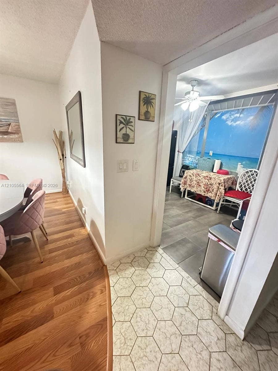 Wood-finish flooring, hexagonal tile flooring, and gray rectangular tile flooring create distinct zones