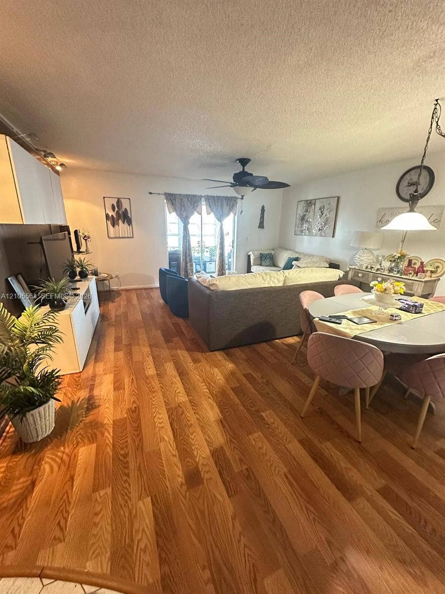 Hardwood flooring throughout, featuring a ceiling fan and track lighting