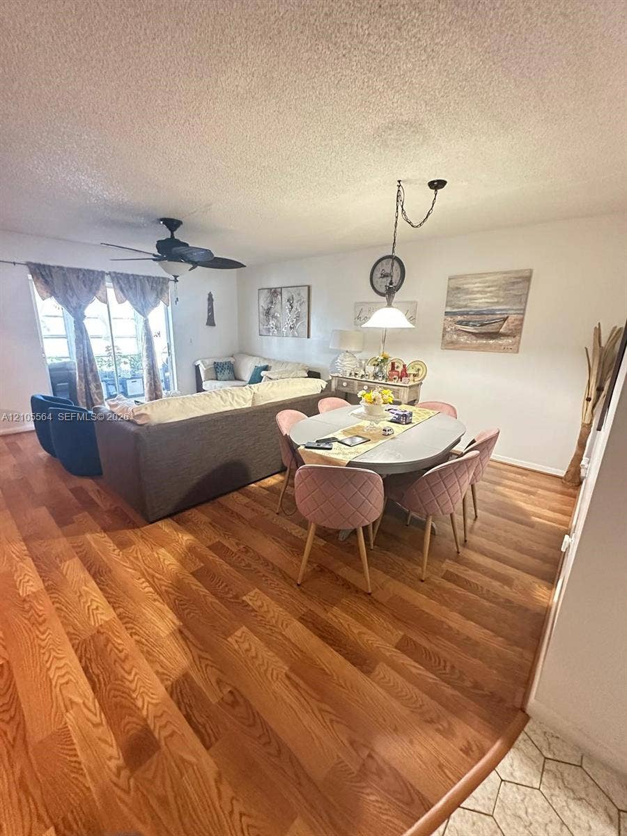 Expansive open-concept living and dining area featuring wood-finish flooring