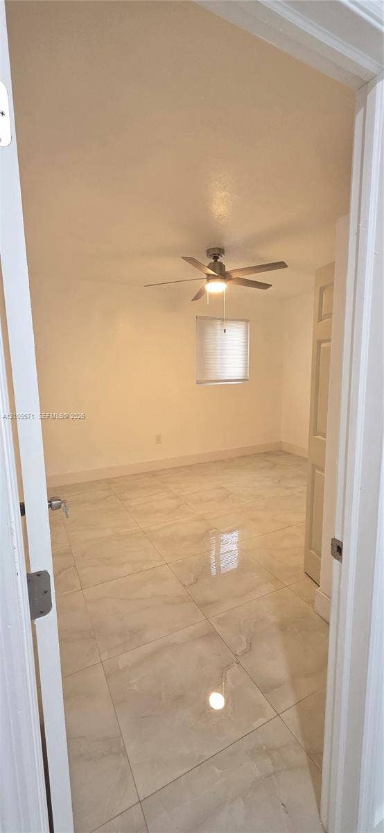 Recessed ceiling lighting, ceiling fan with integrated light, single window with blind, white paneled door, and large format tile flooring