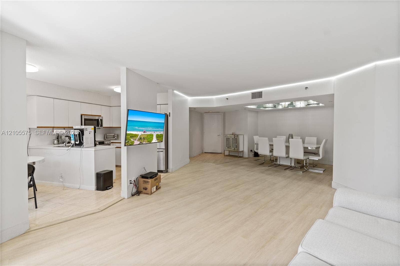 Spacious living room featuring an open-concept kitchen and direct access to a private balcony, creating a bright and inviting living space at Mystic Pointe in Aventura.