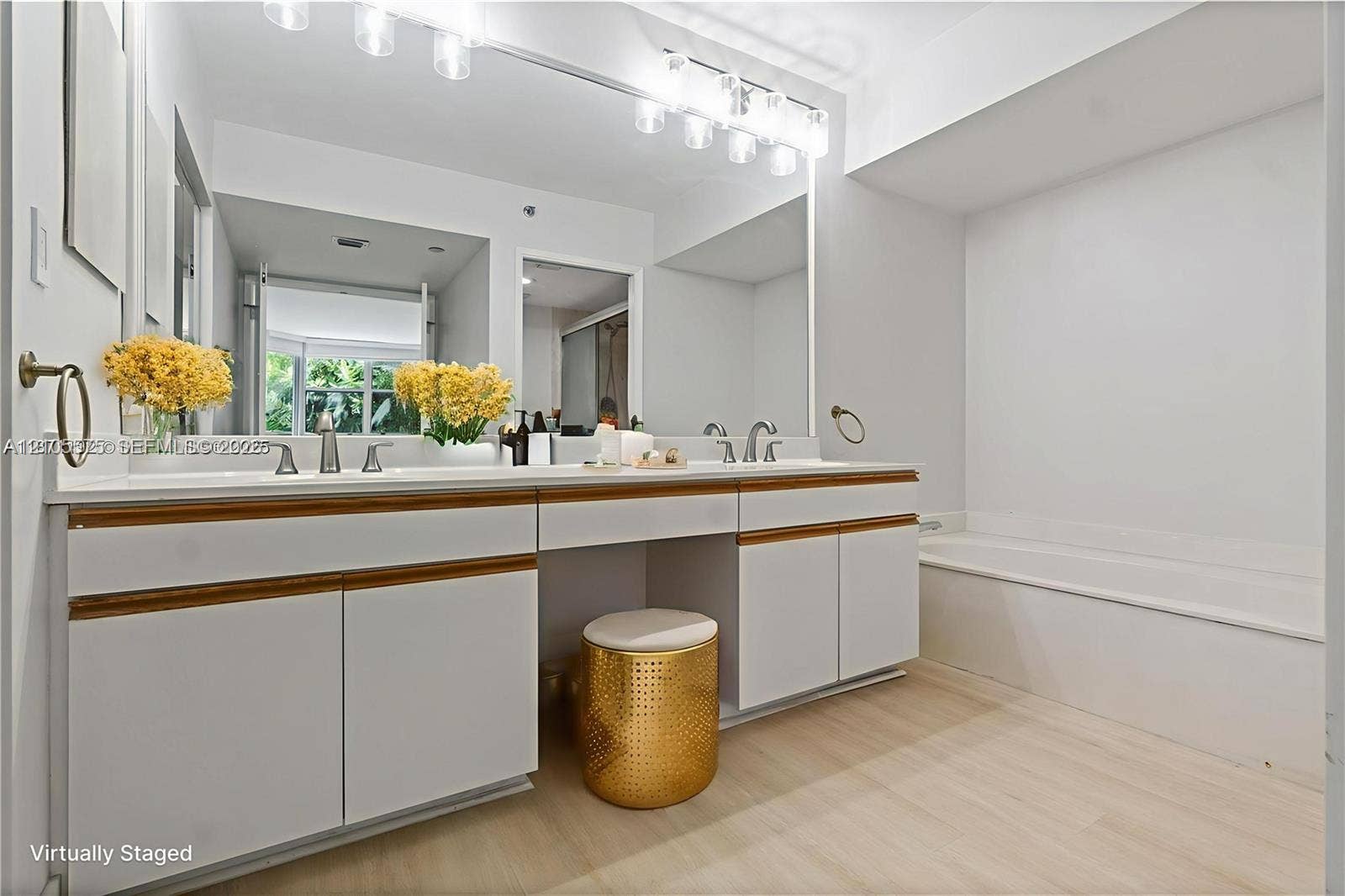Expansive primary bathroom featuring a dual-sink vanity, separate soaking tub, and walk-in shower, offering exceptional space and comfort.