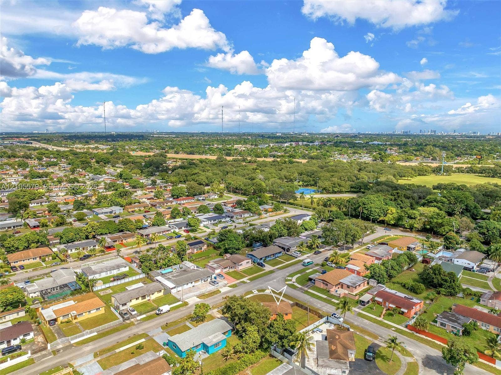 1750 NW 185th Street, Miami Gardens, FL 33056 Aerial perspective featuring a single-story residence situated on a corner lot with mature landscaping and a fenced perimeter